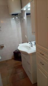 a white bathroom with a sink and a mirror at La casa di Eleonora in Campodolcino