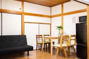 a living room with a table and chairs and a couch at SunRise STAY Atami Ajiro in Ajiro