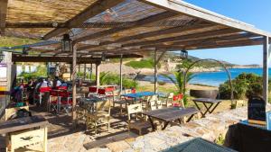 un grupo de mesas y sillas bajo una pérgola de madera en chambre et salle de bain indépendantes à 200m de la plage de Fabrégas, en La Seyne-sur-Mer