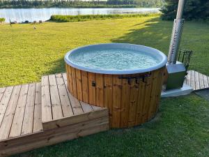 a large hot tub sitting on a wooden deck at Mäeküla Järve Palkmaja in Viljandi