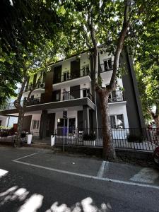 ein großes weißes Gebäude mit Bäumen davor in der Unterkunft Aparthotel Crisvan in Bellaria-Igea Marina