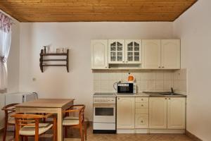 a kitchen with white cabinets and a table at Penzion Pegas Depoltovice in Nová Role
