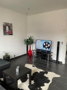 a living room with a couch and a tv at Ferielejlighed i landlige omgivelser in Vejle