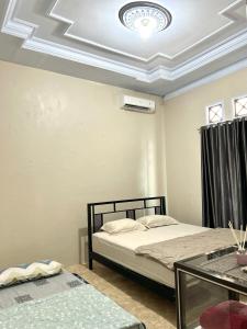 a bedroom with a bed and a coffered ceiling at HARMONI GUEST HOUSE tumpak sewu in Sumberbopong