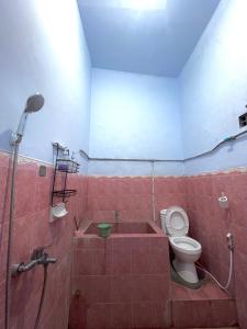 a bathroom with a bath tub and a toilet at HARMONI GUEST HOUSE tumpak sewu in Sumberbopong