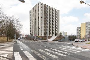 an empty city street with a tall building at Stay2gether Japandi Homestay for 4 - Metro B Luka in Prague