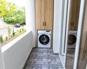 a laundry room with a washer and dryer next to a window at Tskaltubo Apartments in Tsqaltubo