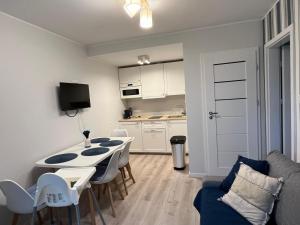 a kitchen and dining room with a table and chairs at Apartament Szept Morza in Debina