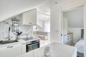 eine weiße Küche mit einem Waschbecken und einem Sofa in der Unterkunft Apartment Paradise in Kotor