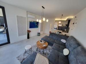 Una sala de estar con un sofá azul y una mesa. en Sea view luxury appartment-parking, en Varna