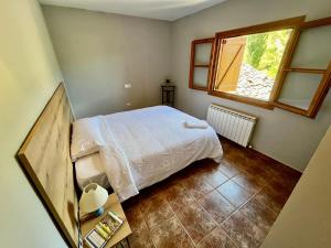 a small bedroom with a bed and a window at Posada OsTablaus in Longás