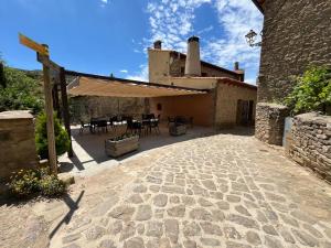 an outdoor patio of a house with a building at Posada OsTablaus in Longás