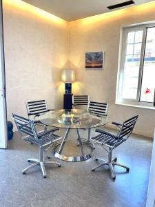 a glass table and chairs in a room at Les Remparts Antibes Location in Antibes