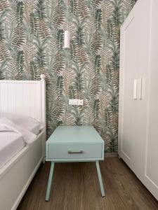 a bedroom with a bed and a blue nightstand with a wallpaper at Molo '93 - RoomsAndSea in Belvedere Marittimo +22 photos