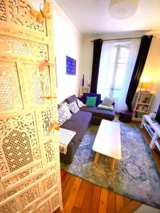 ein Wohnzimmer mit einem Sofa und einer offenen Tür in der Unterkunft Near Paris, charming quiet sunny 2 rooms in Pantin + 2 Fotos