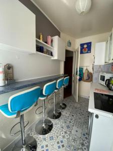 eine Küche mit blauen Barhockern an der Theke in der Unterkunft Near Paris, charming quiet sunny 2 rooms in Pantin