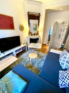 ein Wohnzimmer mit einer blauen Couch und einem Fernseher in der Unterkunft Near Paris, charming quiet sunny 2 rooms in Pantin