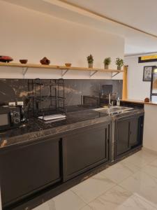 a kitchen with a black counter top and a sink at villa avec piscine in Somone