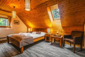 una camera in legno con letto e sedia di Hotel Mikulášska Chata a Demänovská Dolina
