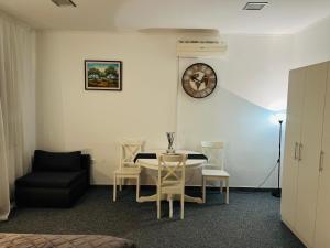 a room with a table and chairs and a clock at WHOLE HOUSE FOREST-yard and BBQ, private parking in Marinići