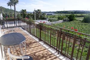 a balcony with a table and chairs and a garden at L'edera appartamento in Rivoli Veronese +8 photos