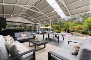 an outdoor living room with couches and tables at 'Avondale' Luxe Country Retreat in Pitt Town