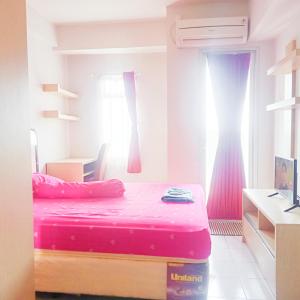 a bedroom with a pink bed and a window at Dramaga Tower Apartemen by Rendy Roomme in Bubulak 3