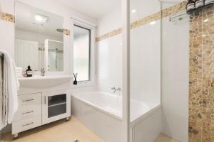 a white bathroom with a tub and a sink at 'Avondale' Luxe Country Retreat in Pitt Town +24 photos