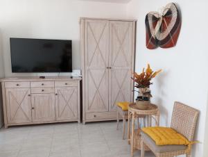 a living room with a television and a wooden cabinet at Atlantic Soul in Playa Blanca