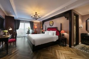 a bedroom with a large white bed and a desk at Acoustic Hotel & Spa in Hanoi