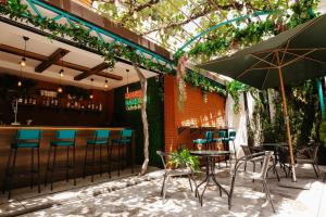 a patio with a bar with chairs and an umbrella at Hotel Imperial House in Tbilisi City