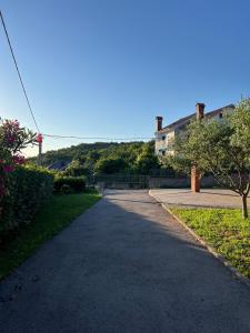 an empty driveway with a house in the background at WHOLE HOUSE FOREST-yard and BBQ, private parking in Marinići