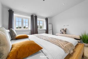 ein Schlafzimmer mit einem großen Bett und zwei Fenstern in der Unterkunft Ferienhaus Loft an der Ostsee Glücksburg in Glücksburg