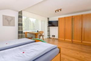 una camera da letto con due letti e un tavolo di Wallgauer Hof a Wallgau Altre 64 foto