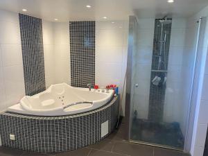 a bathroom with a large tub and a shower at Modern villa i Sävedalen in Gothenburg +18 photos