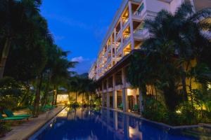 a hotel with a swimming pool in front of a building at Thanthip Beach Resort Patong in Patong Beach