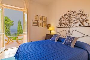 um quarto com uma cama azul e uma varanda em Tenuta Bussadori - Casa Del Maresciallo em Poggio
