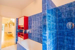 um banheiro de azulejos azuis com banheira e armários vermelhos em Tenuta Bussadori - Casa Del Maresciallo em Poggio mais 38 fotografias