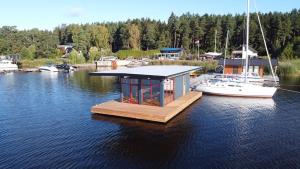 a dock with a small building on the water with boats at StagHorn floating river house in Jūrmala