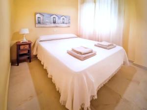 a bedroom with a white bed with towels on it at Banana Beach in Marbella