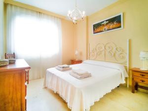 a bedroom with a white bed with towels on it at Banana Beach in Marbella