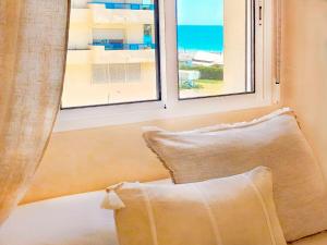 a pillow sitting next to a window with a view of the ocean at Banana Beach in Marbella