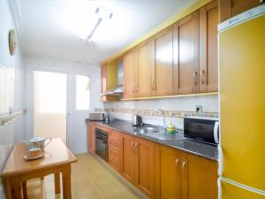 a kitchen with wooden cabinets and a black counter top at Banana Beach in Marbella