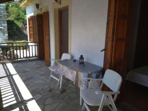 a table and chairs on a patio with a table and chairs at Katerina's apartment in Keramídhion