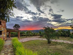 Una puesta de sol sobre un jardín con un camino de piedra. en Chambre d'hôte Ristorante Pizzeria Liberta, en Ranohira