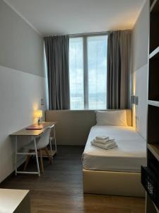 セグラーテにあるFasthotel Linateのベッド、デスク、窓が備わるホテルルームです。 +36枚の写真