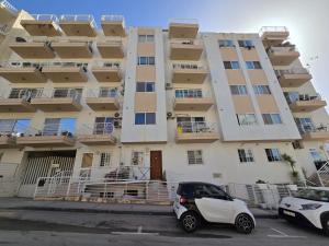 a white car parked in front of a building at Stunning two bed apartment in St Pauls Bay Malta in St Paul's Bay