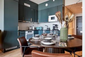 a dining room with a table and chairs and a kitchen at Magnificent luxury for you in Tampere