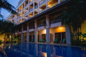 a hotel with a swimming pool in front of a building at Thanthip Beach Resort Patong in Patong Beach