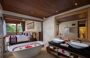 a bathroom with two sinks and a bath tub at Pita Maha Resort & Spa in Ubud